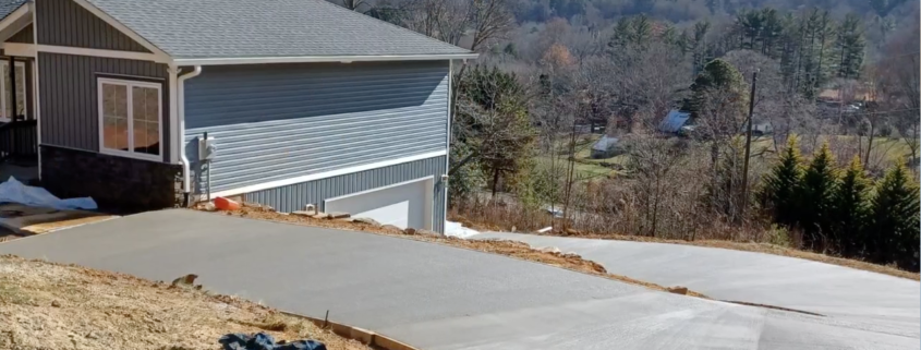 A concrete driveway of a house that overlooks the mountains
