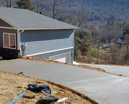 A concrete driveway for a house that overlooks the mountains